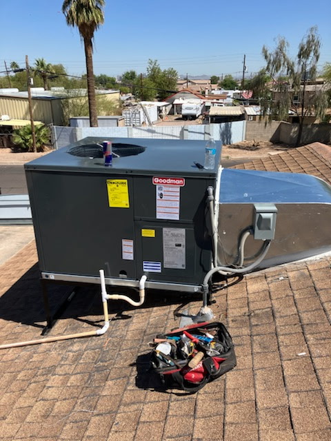 A Goodman rooftop package unit newly set on a Phoenix roof, tools still out